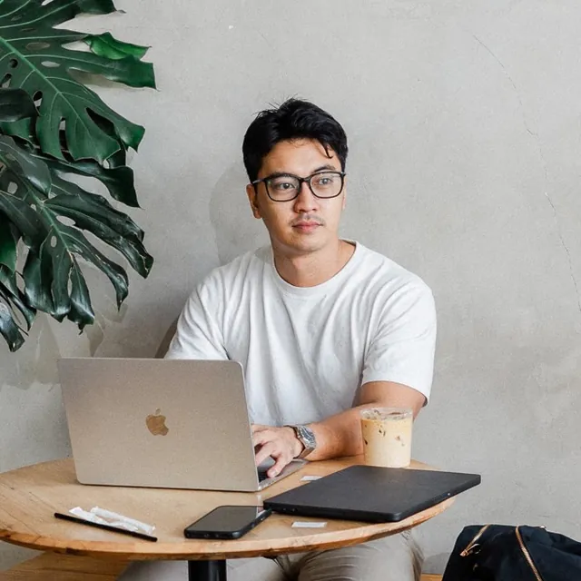 AJ Villalobos working at a table with his laptop